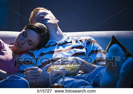 Couple asleep on sofa with bowl of popcorn View Large Photo Image Stock Photo - Couple asleep on sofa with bowl of popcorn. Fotosearch