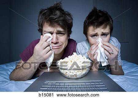 Couple crying with tissue and bowl of popcorn View Large Photo Image Stock Image - Couple crying with tissue and bowl of popcorn. Fotosearch