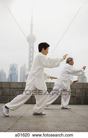 Couple doing tai chi outdoors with city skyline in background View Large Photo Image Stock Image - Couple doing tai chi outdoors with city skyline in background. Fotosearch
