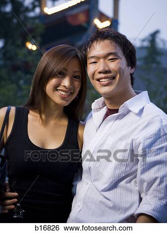 Stock Photograph - Couple embracing and smiling outdoors. Fotosearch