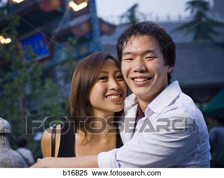 Stock Photography - Couple embracing and smiling outdoors. Fotosearch