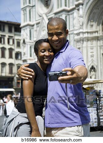 Couple hugging and taking self portrait with camera View Large Photo Image Stock Photograph - Couple hugging and taking self portrait with camera. Fotosearch