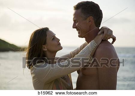Couple hugging on beach View Large Photo Image Stock Image - Couple hugging on beach. Fotosearch