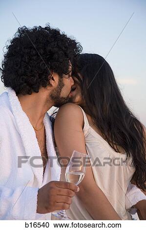 Couple kissing outdoors with champagne flutes View Large Photo Image Stock Image - Couple kissing outdoors with champagne flutes. Fotosearch