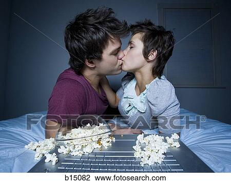 Couple kissing with upside down bowl of popcorn View Large Photo Image Stock Image - Couple kissing with upside down bowl of popcorn. Fotosearch
