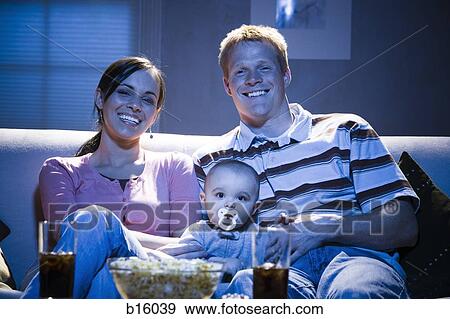 Couple on sofa with baby smiling View Large Photo Image Stock Photo - Couple on sofa with baby smiling. Fotosearch
