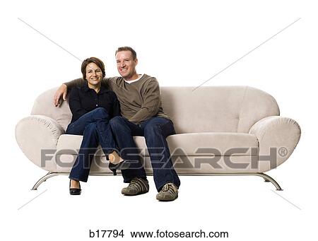 Couple sitting on a couch. View Large Photo Image Picture - Couple sitting on a couch.. Fotosearch