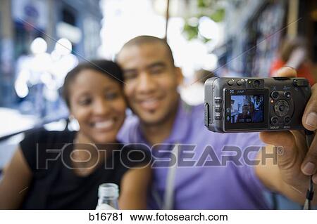 Couple sitting outdoors and posing for photo View Large Photo Image Stock Image - Couple sitting outdoors and posing for photo. Fotosearch