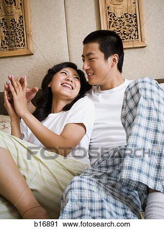 Couple snuggling in bed and smiling View Large Photo Image Stock Image - Couple snuggling in bed and smiling. Fotosearch