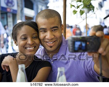 Couple taking a photo of themselves smiling View Large Photo Image Stock Image - Couple taking a photo of themselves smiling. Fotosearch
