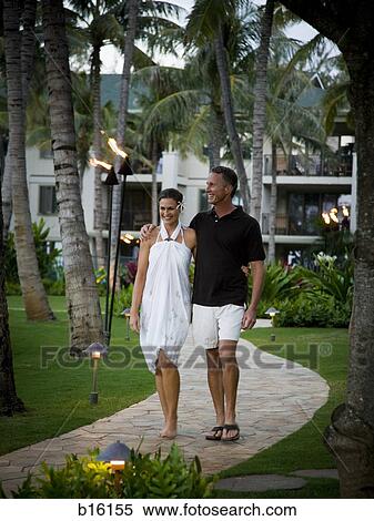 Stock Photography - Couple walking and smiling at resort. Fotosearch