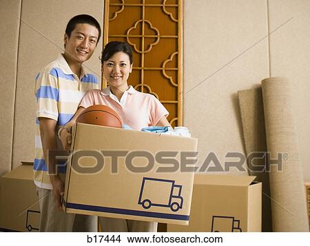 Couple with cardboard box smiling View Large Photo Image Picture - Couple with cardboard box smiling. Fotosearch