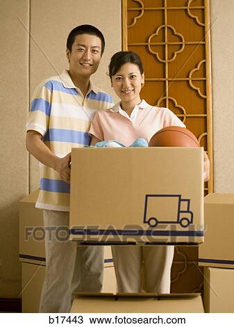 Couple with cardboard box smiling View Large Photo Image Stock Image - Couple with cardboard box smiling. Fotosearch