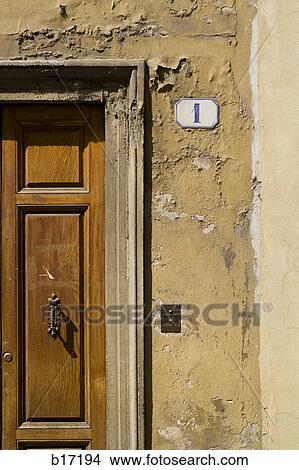 Picture - Detail of number one on wall with wooden door. Fotosearch