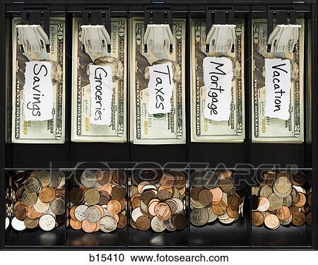 Stock Image - Detailed view of US currency and coins in till with labels for household expenses. Fotosearch