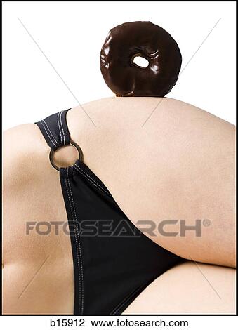 Stock Image - Detailed view of woman in bikini with donut on hip. Fotosearch