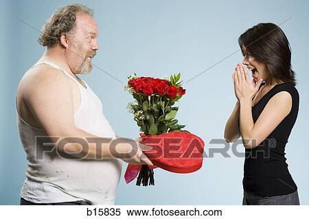 Disheveled man with heart box and red roses with excited woman View Large Photo Image Stock Photography - Disheveled man with heart box and red roses with excited woman. Fotosearch