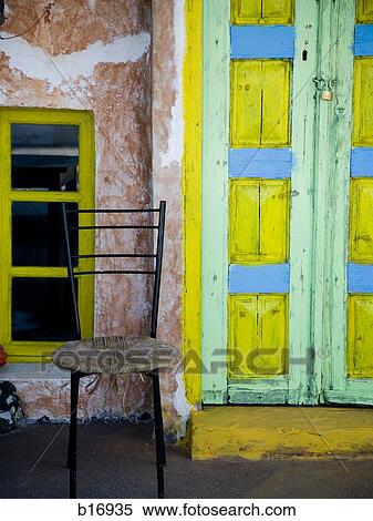 Door painted yellow blue and green with window and empty chair View Large Photo Image Stock Photography - Door painted yellow blue and green with window and empty chair. Fotosearch