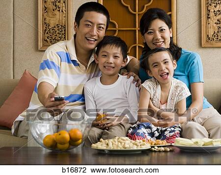 Family on sofa watching television View Large Photo Image Stock Image - Family on sofa watching television. Fotosearch