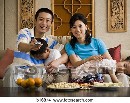 Family watching TV with children asleep View Large Photo Image Picture - Family watching TV with children asleep. Fotosearch