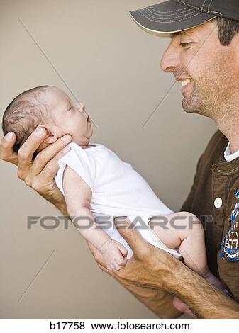 Father holding newborn baby. View Large Photo Image Stock Photo - Father holding newborn baby.. Fotosearch