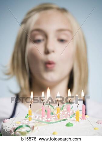 Girl blowing out candles on a birthday cake View Large Photo Image Stock Photograph - Girl blowing out candles on a birthday cake. Fotosearch