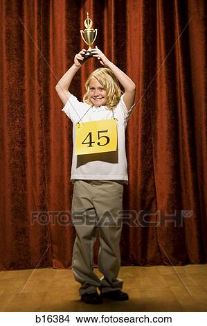 Girl contestant holding trophy and smiling View Large Photo Image Picture - Girl contestant holding trophy and smiling. Fotosearch