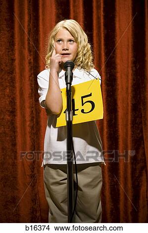 Girl contestant standing at microphone thinking View Large Photo Image Picture - Girl contestant standing at microphone thinking. Fotosearch