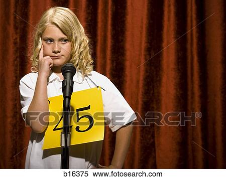 Stock Photography - Girl contestant standing at microphone thinking. Fotosearch