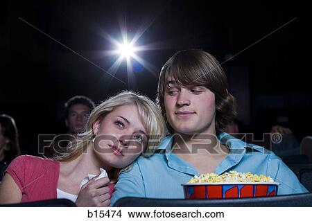 Picture - Girl crying at movie theater with boy and popcorn. Fotosearch