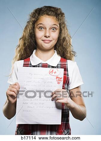 Girl holding A plus paper smiling View Large Photo Image Picture - Girl holding A plus paper smiling. Fotosearch