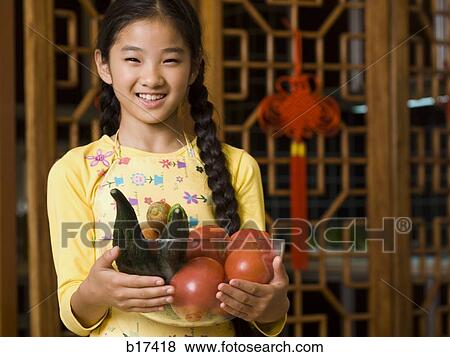 Girl holding bowl of vegetables smiling View Large Photo Image Stock Photo - Girl holding bowl of vegetables smiling. Fotosearch