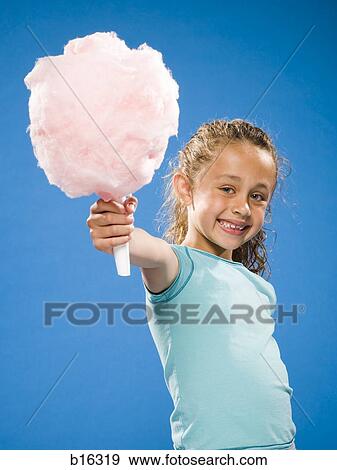 Girl holding cotton candy smiling View Large Photo Image Stock Photo - Girl holding cotton candy smiling. Fotosearch