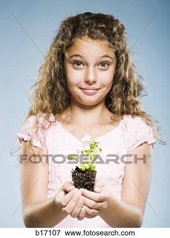 Girl holding seedling smiling View Large Photo Image Stock Photo - Girl holding seedling smiling. Fotosearch