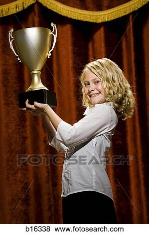 Girl holding trophy cup smiling View Large Photo Image Stock Photo - Girl holding trophy cup smiling. Fotosearch
