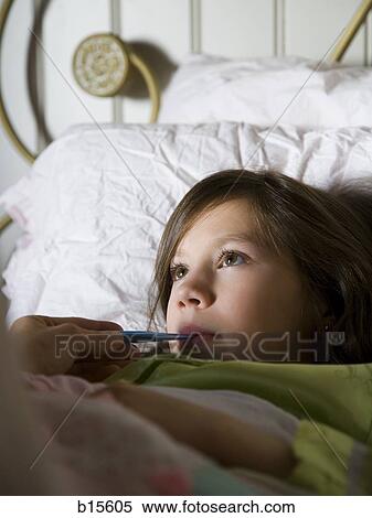 Girl in bed with thermometer View Large Photo Image Stock Photography - Girl in bed with thermometer. Fotosearch