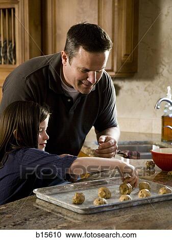 Girl in kitchen with man baking cookies View Large Photo Image Stock Image - Girl in kitchen with man baking cookies. Fotosearch