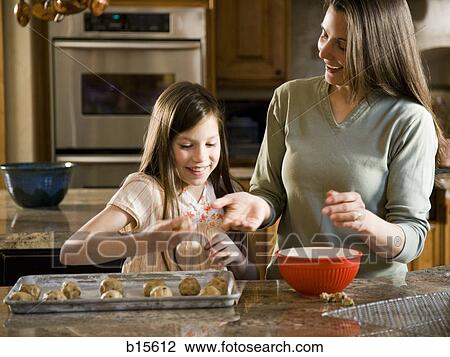 Girl in kitchen with woman baking cookies View Large Photo Image Stock Image - Girl in kitchen with woman baking cookies. Fotosearch