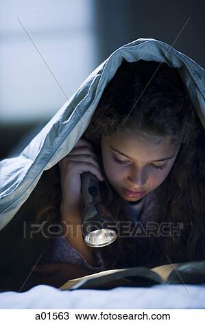 Girl laying in bed under blanket with flashlight reading View Large Photo Image Stock Image - Girl laying in bed under blanket with flashlight reading. Fotosearch