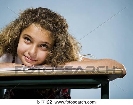 Girl leaning on desk with workbook smiling View Large Photo Image Stock Image - Girl leaning on desk with workbook smiling. Fotosearch