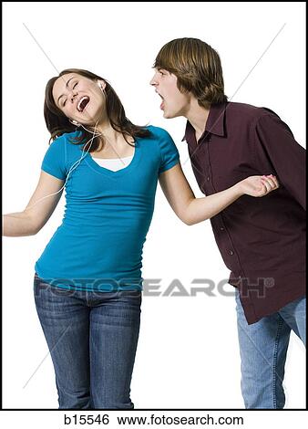Stock Photograph - Girl listening to mp3 player with boy yelling. Fotosearch