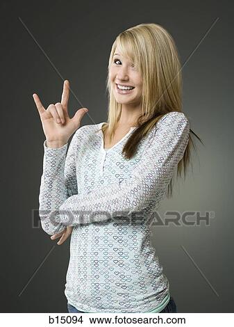 Picture - Girl making hand gesture and smiling. Fotosearch