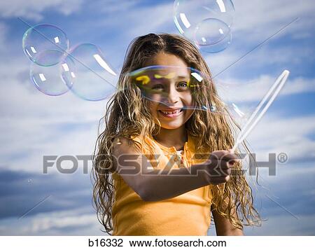 Girl outdoors with bubbles smiling View Large Photo Image Stock Image - Girl outdoors with bubbles smiling. Fotosearch
