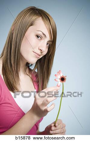 Stock Photo - Girl picking petals off flower. Fotosearch