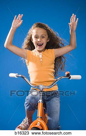 Girl riding orange bicycle with no hands laughing View Large Photo Image Stock Image - Girl riding orange bicycle with no hands laughing. Fotosearch