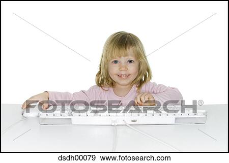 Stock Photo - Girl sitting at keyboard smiling. Fotosearch