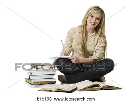 Girl sitting cross legged doing homework smiling View Large Photo Image Stock Image - Girl sitting cross legged doing homework smiling. Fotosearch