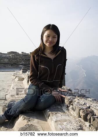 Girl sitting on ledge at Great Wall of China View Large Photo Image Stock Image - Girl sitting on ledge at Great Wall of China. Fotosearch