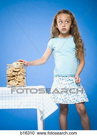 Girl sneaking Chocolate Chip Cookie from cookie jar View Large Photo Image Stock Image - Girl sneaking Chocolate Chip Cookie from cookie jar. Fotosearch