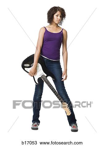 Girl standing and holding electric guitar View Large Photo Image Stock Image - Girl standing and holding electric guitar. Fotosearch
